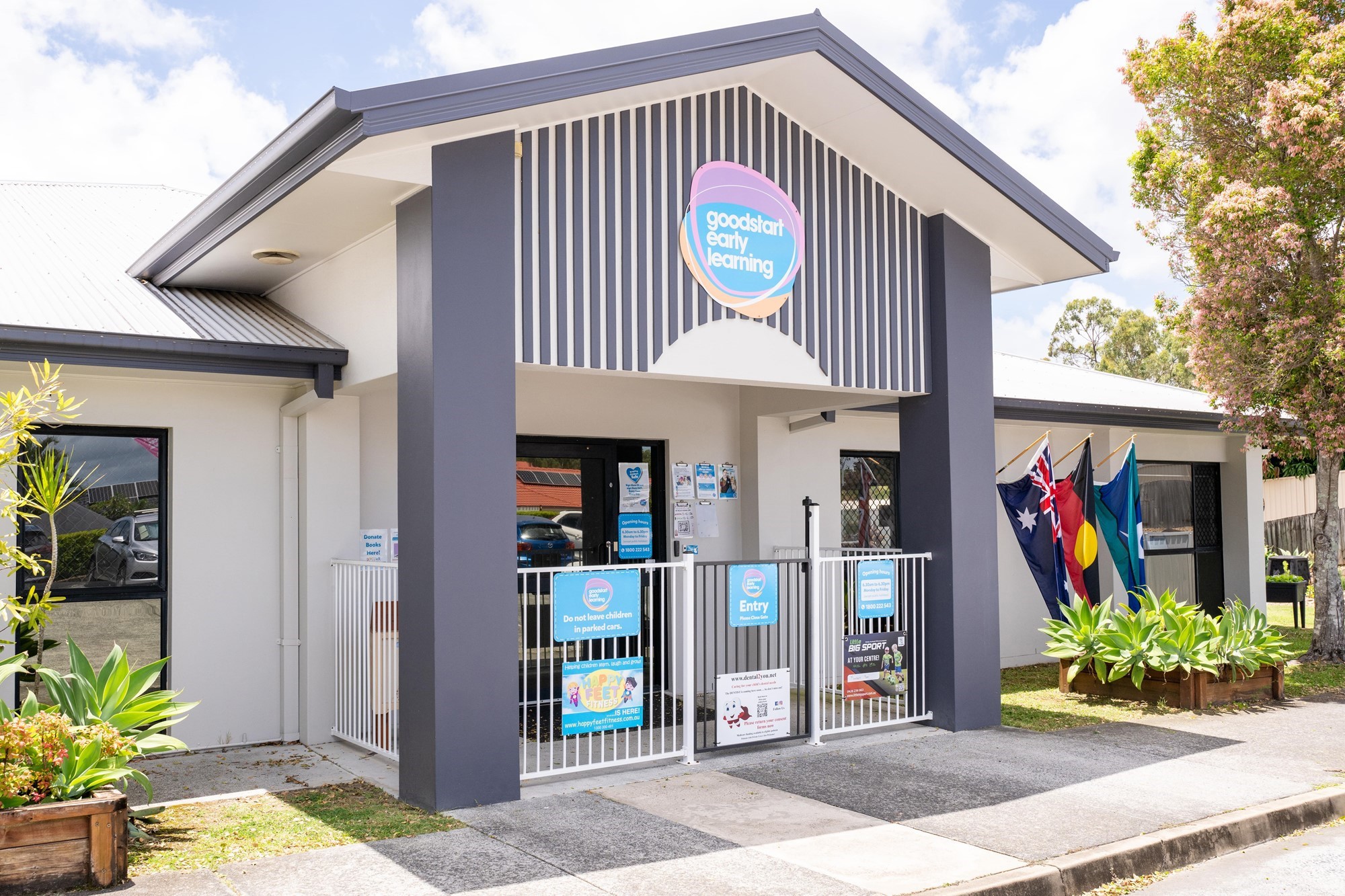 The welcoming front entrance of Goodstart Early Learning Gaven - Pacific Pines, featuring flags and a vibrant atmosphere. Our centre offers a nurturing, family-oriented environment where children can grow, learn, and thrive. Located in the heart of Pacific Pines, we provide high-quality early education and care that families trust.